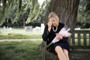 Elderly woman visiting grave loved one